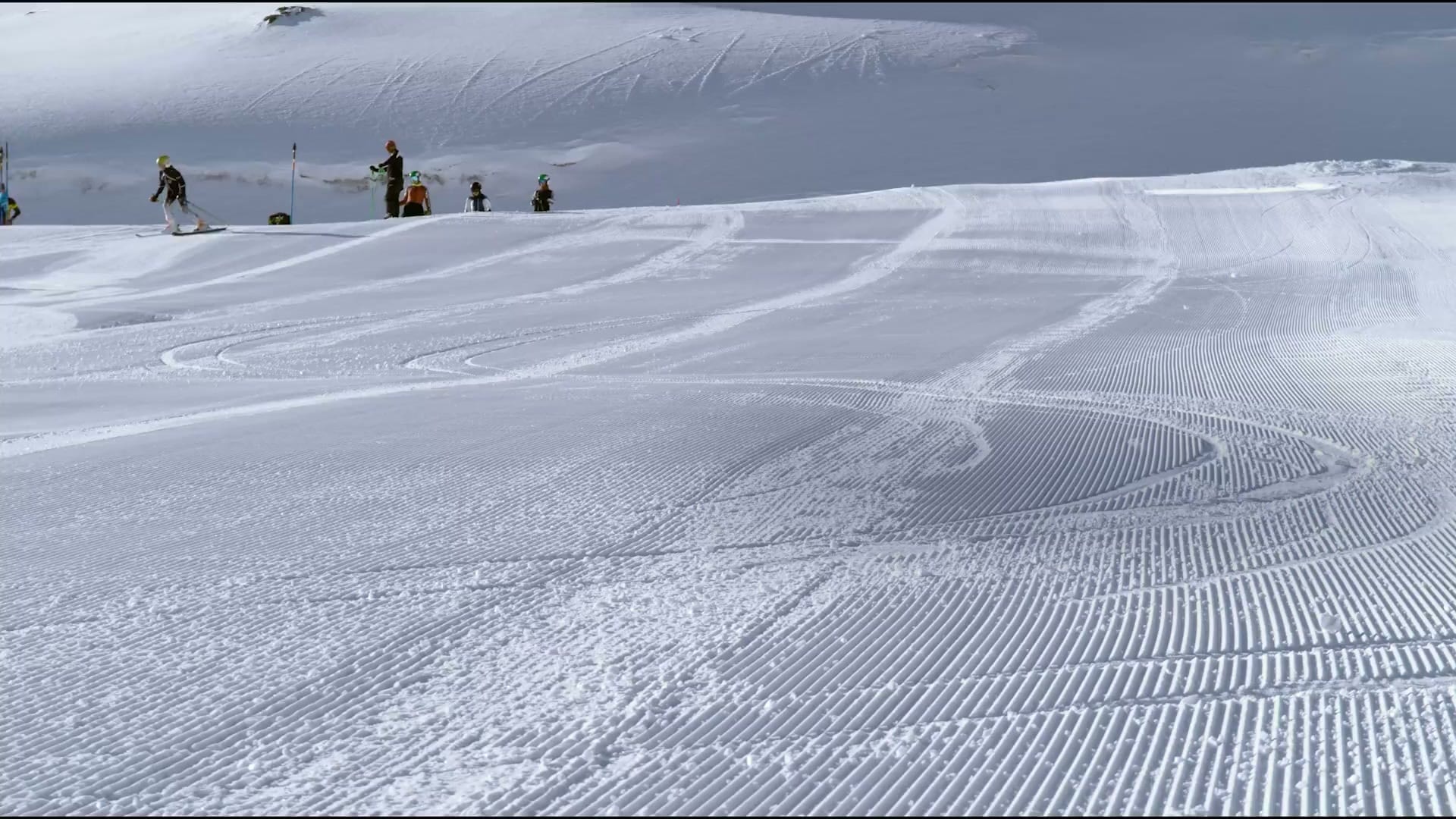 Skier carving fresh corduroy on a groomed piste